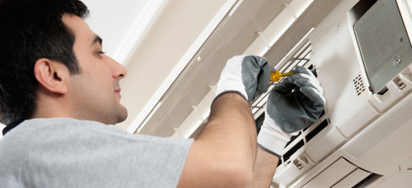 a commercial hvac technician fixing a ductless sytem